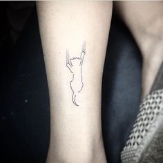 a woman's arm with a cat tattoo on the left side of her body