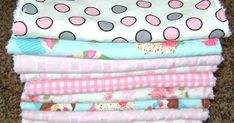 a stack of cloths sitting on top of a carpet covered in pink and white polka dots