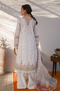 Description: This exquisite ivory and light pink 3 piece lawn Pakistani women's outfit from Qalamkar is the epitome of elegance and sophistication. The chikankari gota embroidered kurta is a stunning work of art, featuring intricate embroidery and delicate details. The outfit is completed with a digitally printed dupatta and wide leg plain lawn trouser, making it a perfect choice for any formal or semi-formal occasion. Materials: Shirt (Lawn) - Chikankari Gotta Embroidered with digital printingDupatta (Organza) - Digital Printed Embroidered Dupatta with laceTrouser (Lawn) - Plain Trouser *Disclaimer: Due to the many variations in monitors and browsers, the color of products may appear different on different monitors. **Additional decorative trim has been added to the outfit in the photos. White Eid Dress, Pakistani Boutique, Dupatta Style, Eid Dress, Pakistani Designer Clothes, Eid Dresses, Organza Dupatta, Embroidered Neckline, Pakistani Designers