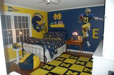 a bedroom decorated in blue, yellow and white with football themed decor on the walls