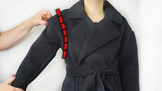 a woman in a black coat with red pins on it