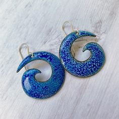 Spirals have a special place in my heart. They are beautiful organic forms created by nature. As with many natural elements, we can see more meaning in spirals than just their physical structure. The symmetry and potentially endless nature of a spiral reflects a single shell on the beach or an entire galaxy. These bold spiral copper enamel earrings will top off your beachy ensemble with flair. I heat the pieces longer to pull a lighter blue enamel through a royal blue top coat. The result: natur Nickel-free Spiral Blue Earrings, Blue Artsy Jewelry For Beach, Artsy Blue Enamel Jewelry, Unique Blue Spiral-shaped Jewelry, Blue Spiral, Royal Blue Top, Special Place In My Heart, Organic Forms, Fire Glass