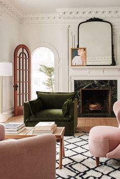 a living room filled with furniture and a fire place under a mirror on the wall