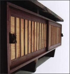 a wooden wall shelf with an animal head sticking out of it's hole in the wood