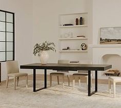 a dining room table and chairs in front of a fireplace