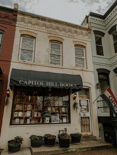 an old brick building with lots of windows on the front and side of it that says capitol hill books