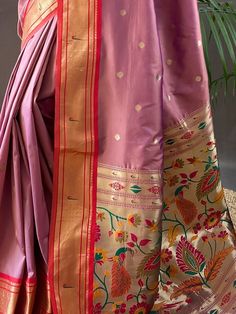 Wear this gorgeous dusty pink paithani silk saree and become the cynosure of all eyes. Crafted with meticulous attention to detail, this stunning saree is perfect for weddings, receptions, functions, and any other event where you want to be the center of attraction.
Made from high-quality silk material, this saree boasts a rich and luxurious dusty pink color. The zari weaving work adds a touch of elegance and sophistication, making it a truly exquisite piece. The saree also features an elegant r Pink Paithani Silk Traditional Wear For Wedding, Pink Meenakari Saree For Wedding, Pink Meenakari Traditional Wear For Festivals, Pink Paithani Silk Traditional Wear For Festivals, Pink Paithani Silk Traditional Wear For Navratri, Pink Paithani Silk Traditional Wear For Eid, Pink Paithani Silk Saree For Eid, Pink Meenakari Saree For Traditional Ceremonies, Pink Paithani Silk Traditional Wear With Zari Work