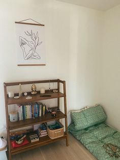 a small room with a bed, bookshelf and other items on the floor