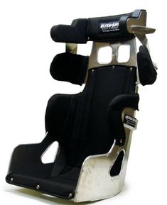 a black and silver racing seat sitting on top of a white floor with no wheels