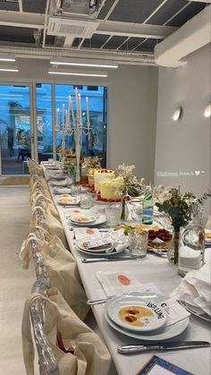 a long table is set up with plates and silverware