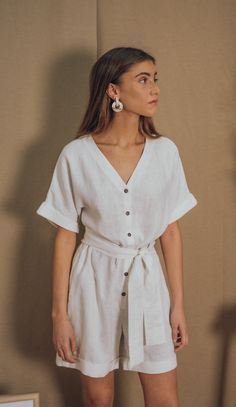 OUR GAELLE LINEN JUMPSUIT IS ELEGANT AND COMFY AT THE SAME TIME. YOU CAN WEAR IT  LOOSE OR CINCHED AT THE WAIST. BUTTONED FRONT, WIDE PATTERN AND SIDE POCKETS.THE PERFECT PIECE FOR ALL YOUR SUMMER WANDERINGS! BLUE ANEMONE IS A SUSTAINABLE, ETHICAL AND ARTISANAL BRAND, ALL OUR STYLES ARE HANDMADE USING THE BEST SUSTAINABLE MATERIALS LIKE LINEN, COTTON,HEMP AND RAMIE. ALL OUR ORDERS ARE CUSTOM MADE TO AVOID GENERATING OVERSTOCKS AND MORE WASTE TO OUR BELOVED PLANET ALL OUR CLOTHES ARE ETHICALLY PR Chic Linen Jumpsuits And Rompers With Tie Waist, Spring Linen V-neck Jumpsuit, Spring Linen Jumpsuit With V-neck, Linen V-neck Jumpsuits And Rompers For Spring, Chic Linen Jumpsuits And Rompers With Short Sleeves, Chic Linen Jumpsuits And Rompers For Day Out, White Linen Summer Dress For Work, White Linen Beach Jumpsuits And Rompers, White Linen Dress For Summer Workwear