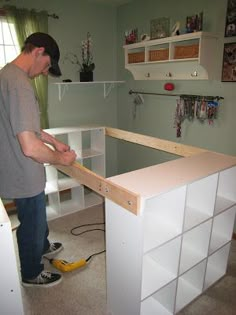 a man standing in front of a white cabinet