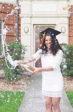 a woman in a graduation cap and gown is throwing snow into the air