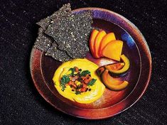 a plate topped with fruit and crackers on top of a table