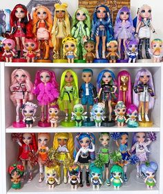 a shelf filled with lots of different colored dolls