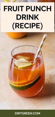 a glass filled with fruit punch drink next to an orange and lime on the table