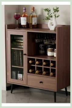 a wooden cabinet with bottles and glasses on top