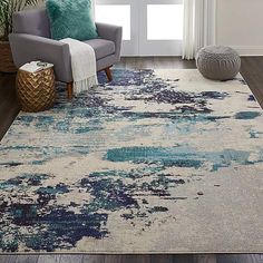 an area rug with blue and white paint splattered on it in a living room