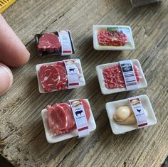 small plastic containers filled with raw meat on top of a wooden table next to a measuring tape