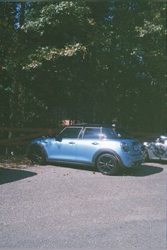 two cars parked in a parking lot next to trees