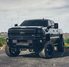 a large black truck parked on top of a parking lot