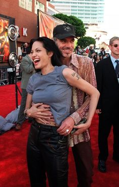 a man and woman are hugging on the red carpet