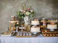 a table topped with lots of cakes and cupcakes