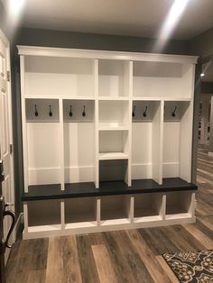 an empty room with several white and black shelves