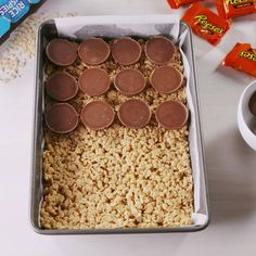 a pan filled with rice and chocolates next to some candy