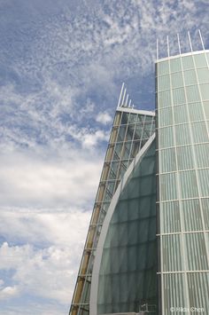 a very tall building with a clock on it's side and sky in the background