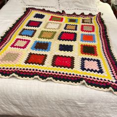 a crocheted blanket sitting on top of a bed