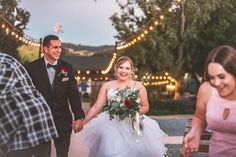 a bride and groom holding hands as they walk down the aisle