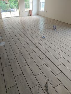 an empty room with wood flooring and broken tiles