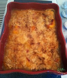 a casserole dish with meat and vegetables in it sitting on a stove top