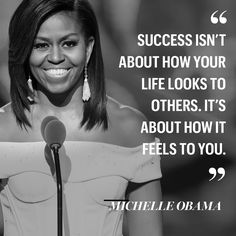 the first lady smiles as she stands in front of a microphone with an inspirational quote above her