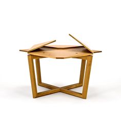 a small wooden table with an open top and two sections on each side, sitting on a white surface