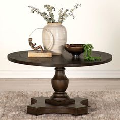 a table that has some plants on it and a vase with flowers sitting on top