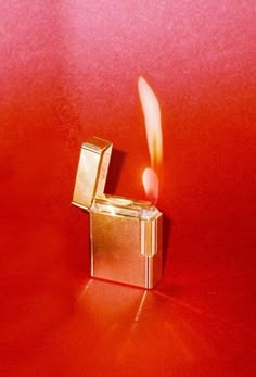 a lighter is lit on a red surface