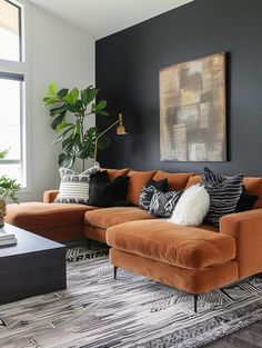 a living room with black walls and orange couches