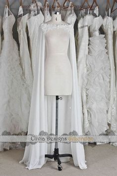 a mannequin in front of wedding gowns on display at a bridal shop