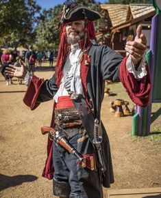 a man dressed in pirate garb giving the thumbs up