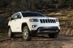 a white jeep parked on top of a dirt hill