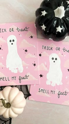 two pink halloween cards with white ghost on them next to a spooky pumpkin