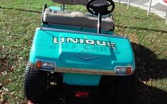 a blue golf cart parked in the grass