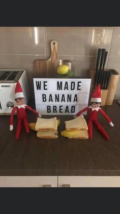 two elfs are sitting next to a sign that says, we made banana bread