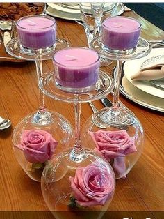 three wine glasses with candles in them sitting on a table