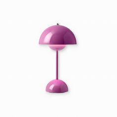 a purple table lamp sitting on top of a white wall