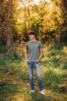 a young man is standing in the grass