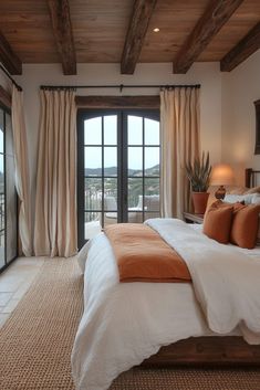 a bedroom with a large bed and sliding glass doors leading to an outdoor deck area