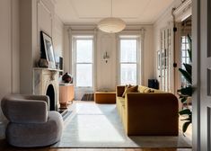 a living room filled with furniture and a fire place in the middle of a room